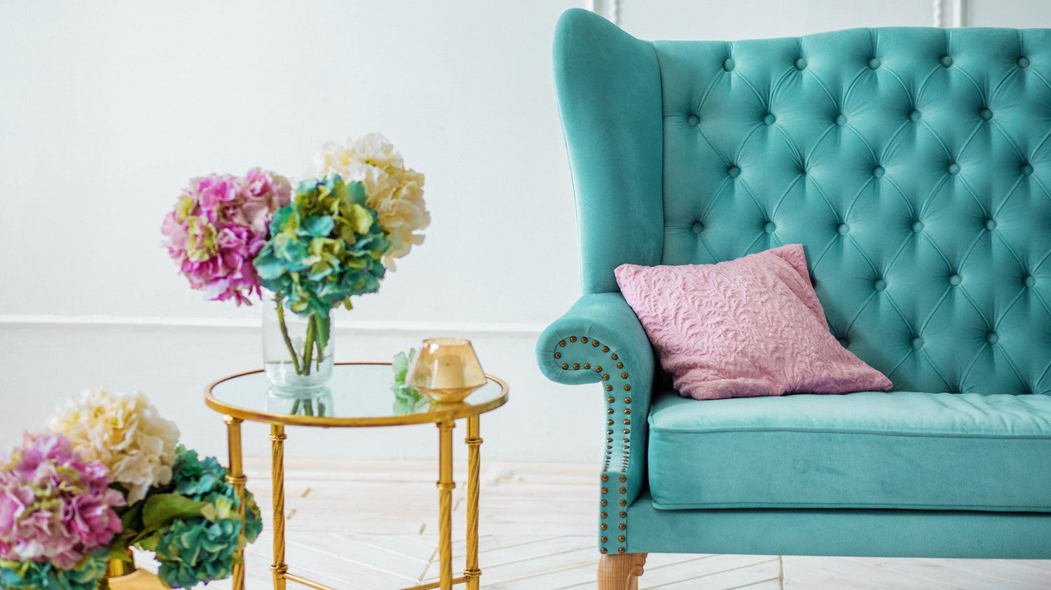 Green Armchair in Room with Colourful Flowers in Glass Vase on Glass Table