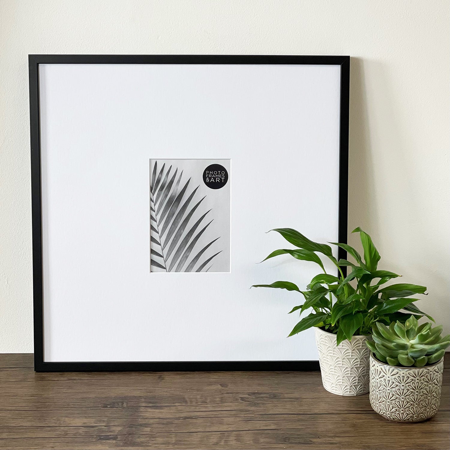 Oversized Mount Wooden 18x18 Black Frame for 7x5 with a Photo of a Plant and PF&A Logo