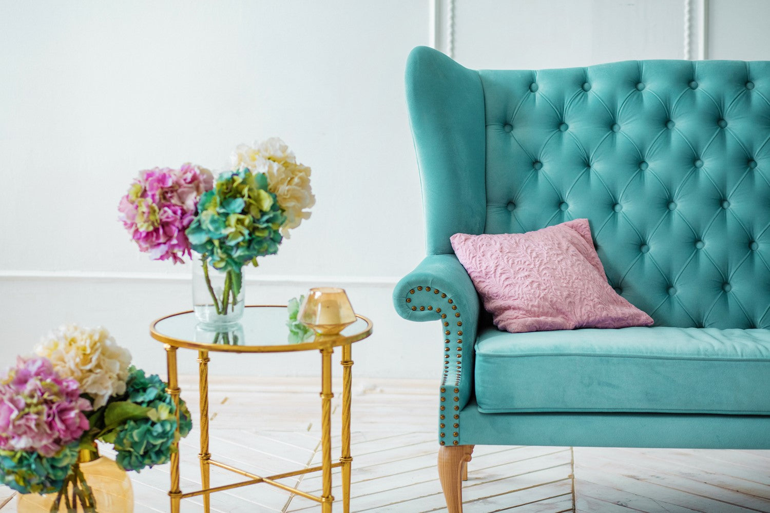 Green Armchair in Room with Colourful Flowers in Glass Vase on Glass Table